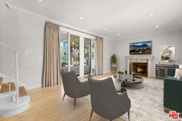 a living room with furniture a fireplace and a floor to ceiling window