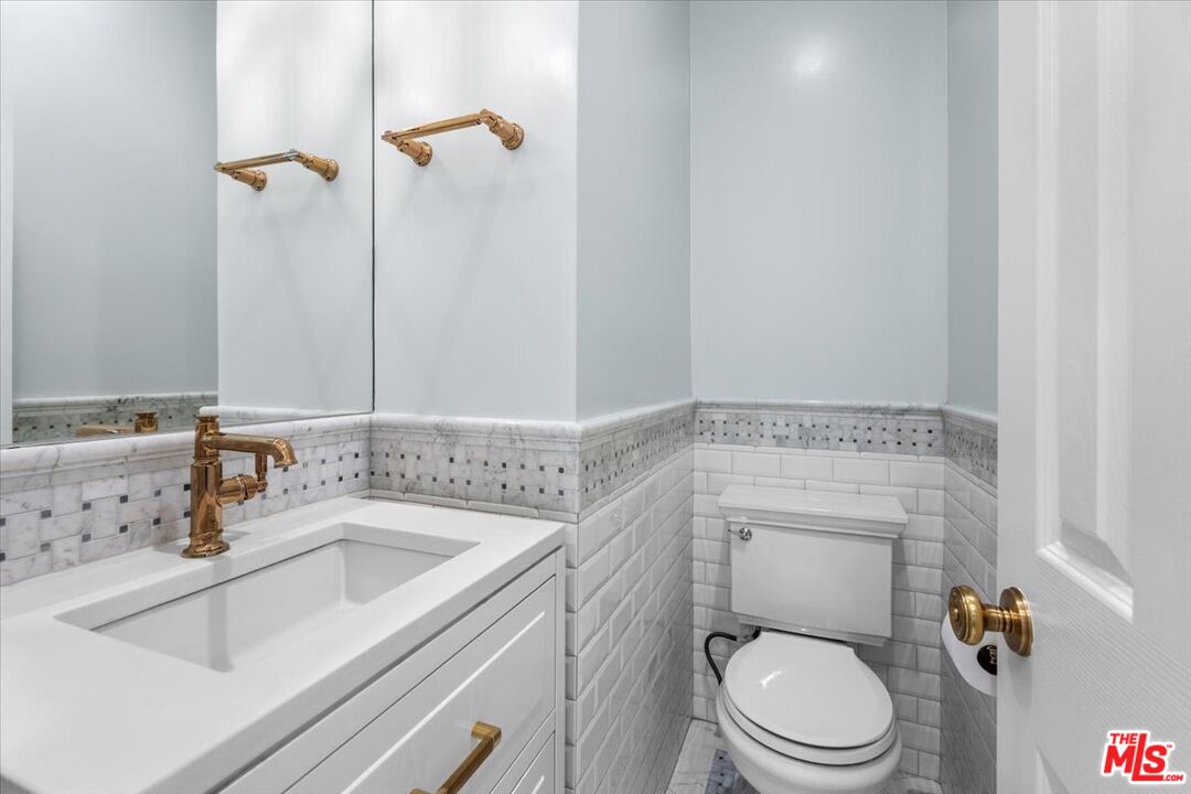 9683 West Olympic Boulevard Beverly Hills, CA 90212 - Photo 8 of 20 a bathroom with a sink a toilet and a mirror