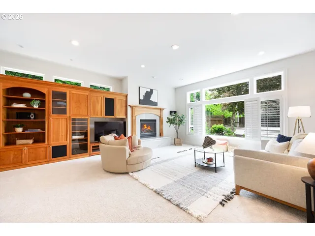 a living room with furniture a fireplace and a large window
