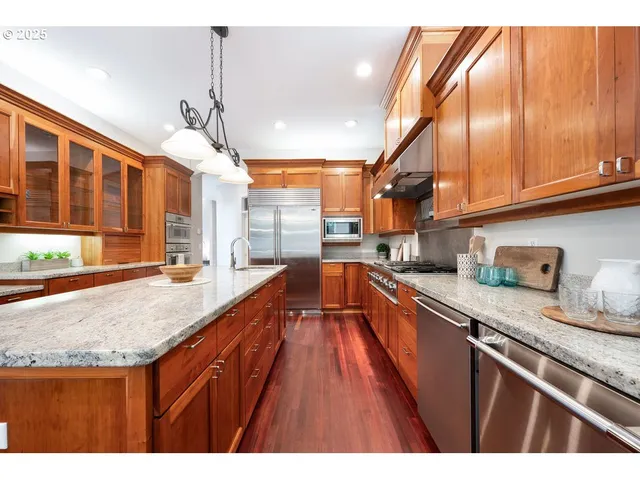 a kitchen with stainless steel appliances granite countertop a sink stove and refrigerator