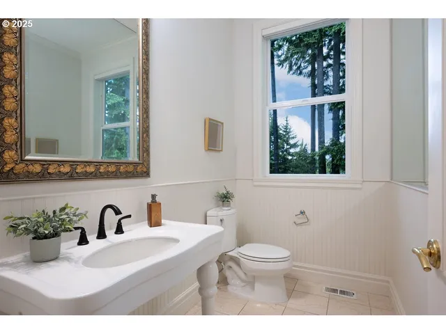 a bathroom with a sink a toilet and a window