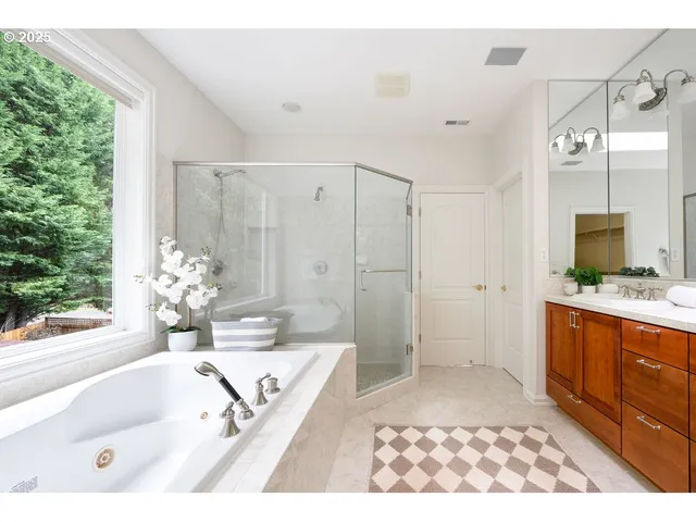 a spacious bathroom with a tub sink and mirror