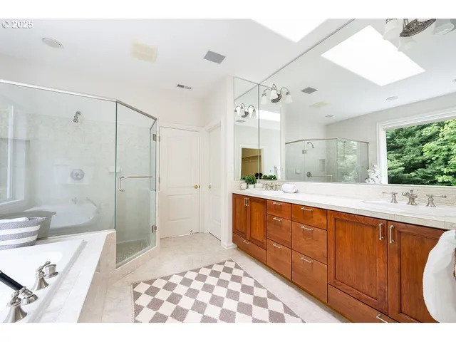a spacious bathroom with a double vanity sink toilet mirror and bathtub