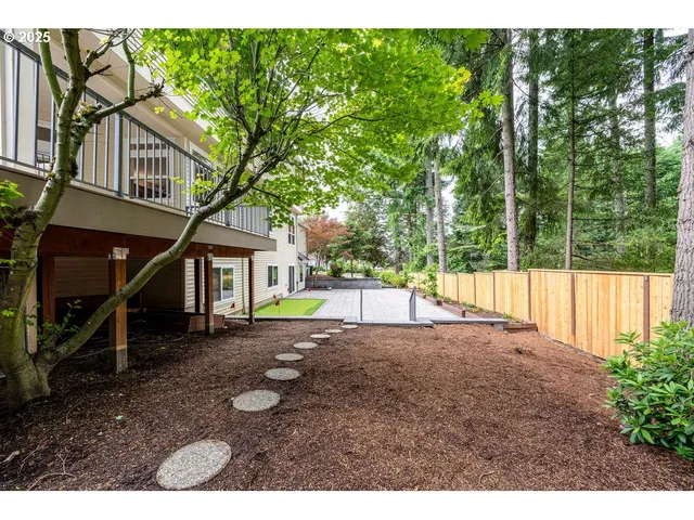 a view of a white house with a yard and sitting area