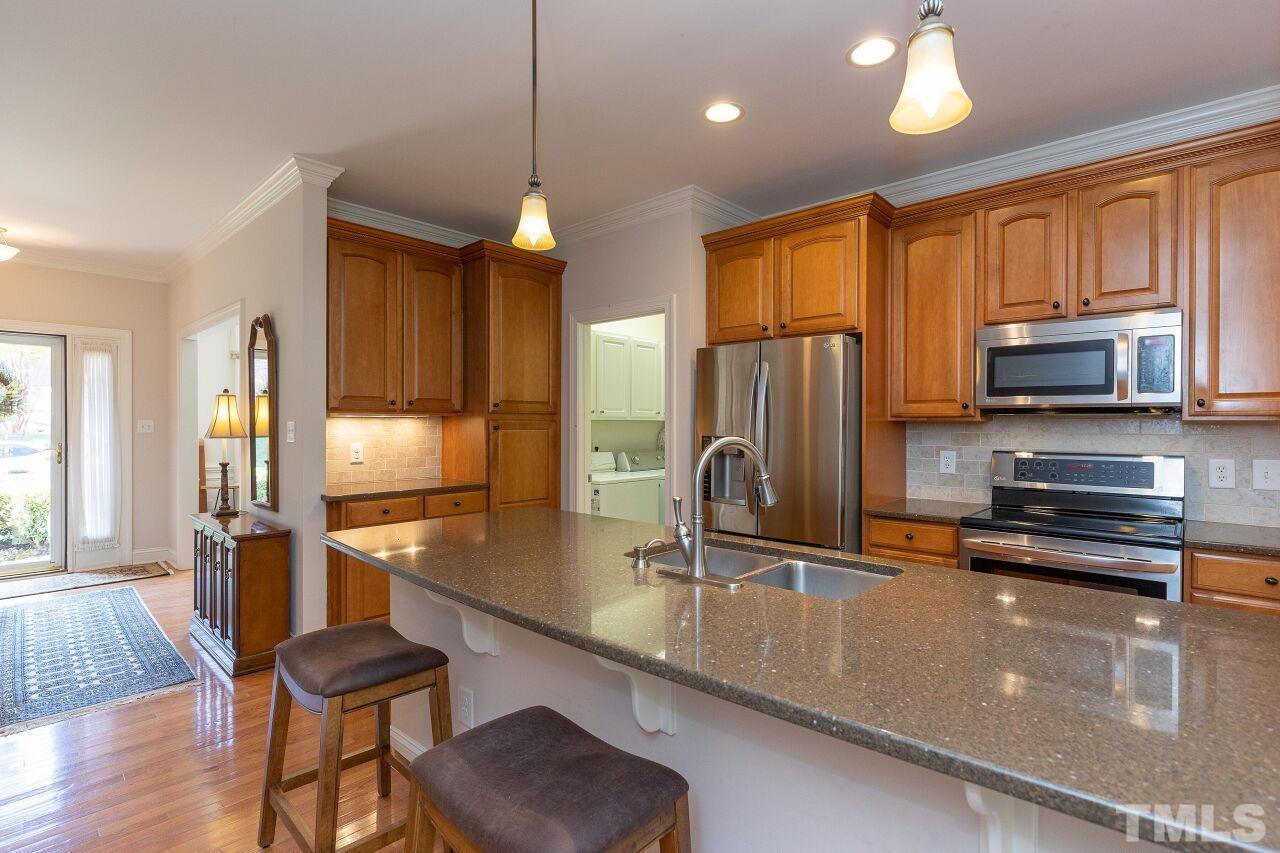 7382 Fontana Ridge Lane Raleigh, NC 27613 - Photo 9 of 30 a kitchen with stainless steel appliances granite countertop a refrigerator a stove top oven a sink dishwasher and wooden cabinets with wooden floor