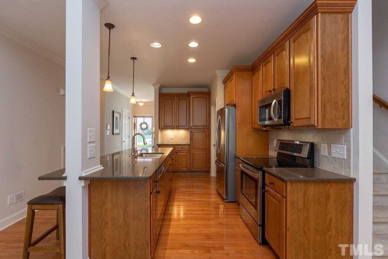 7382 Fontana Ridge Lane Raleigh, NC 27613 - Photo 10 of 30 a kitchen with stainless steel appliances granite countertop sink stove refrigerator and cabinets