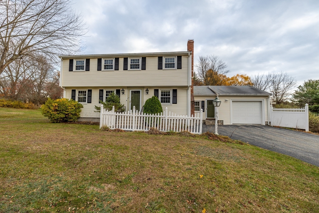 a view of a house with a yard and fence