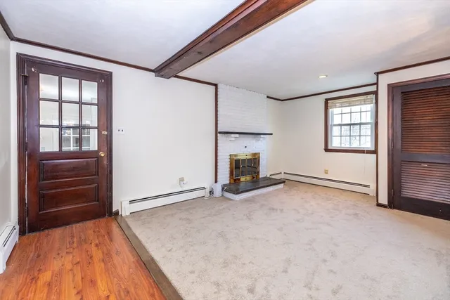 a view of an empty room with a fireplace and a window