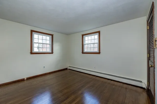 a view of a room that has wooden floor and windows in it