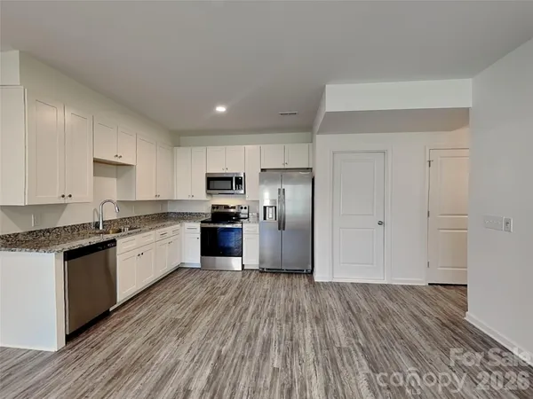 a large kitchen with granite countertop a large counter top space stainless steel appliances and cabinets