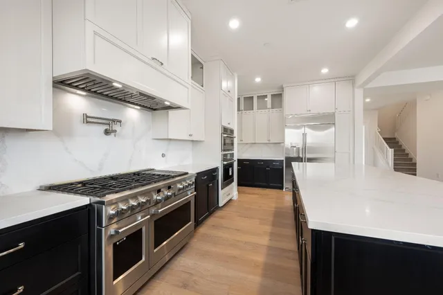 a kitchen with stainless steel appliances granite countertop a stove and a refrigerator