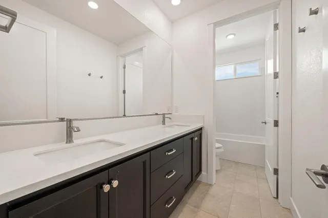 a bathroom with a double vanity sink and a mirror