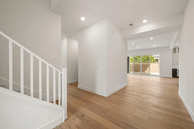 a view of a hallway with wooden floor and windows