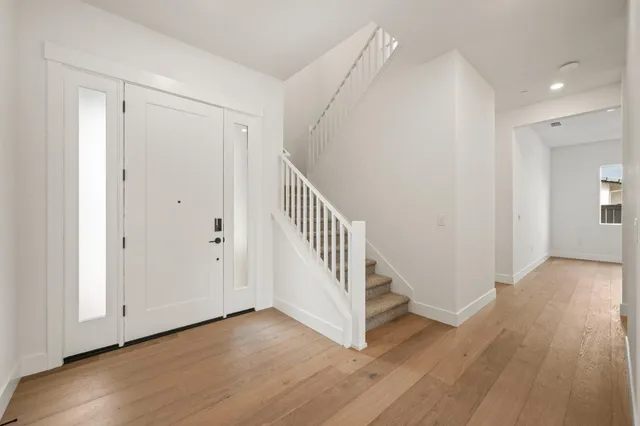 a view of a hallway with wooden floor and entryway
