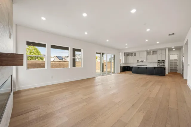 a view of empty room with a kitchen and windows