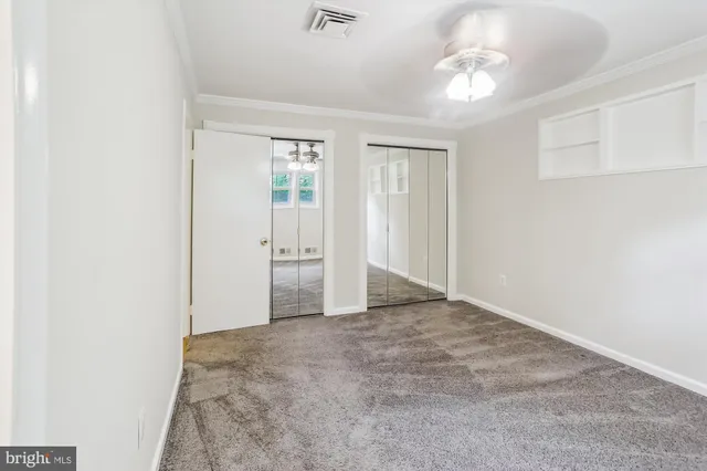 an empty room with windows and closet