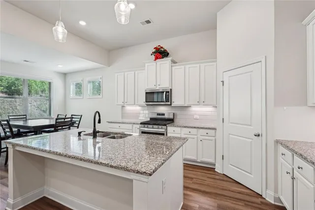 a kitchen with stainless steel appliances granite countertop a sink stove and refrigerator