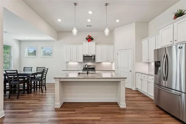 a kitchen with granite countertop a sink appliances cabinets and counter space