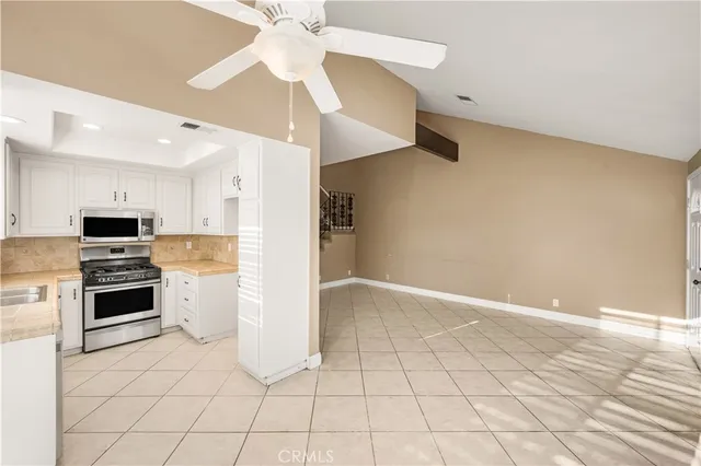 a kitchen with white cabinets and stainless steel appliances