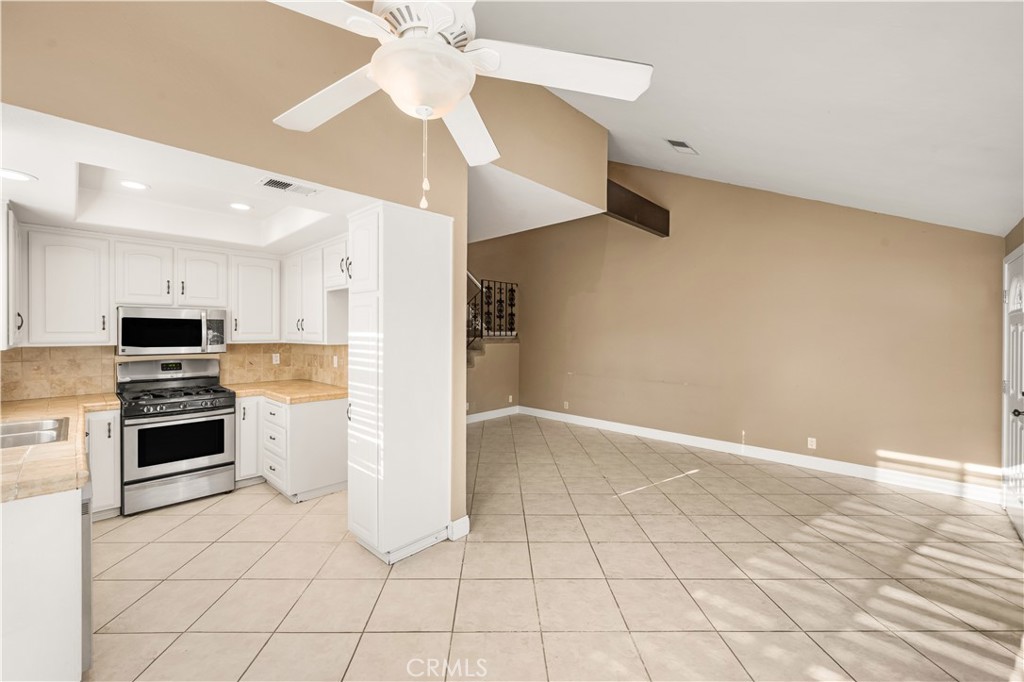 1062 Walnut Street, Unit C Tustin, CA 92780 - Photo 12 of 41 a kitchen with white cabinets and stainless steel appliances