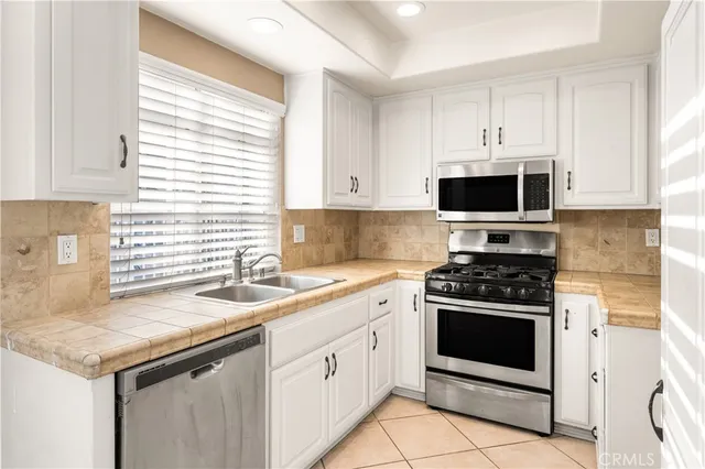 a kitchen with stainless steel appliances granite countertop a sink and a stove