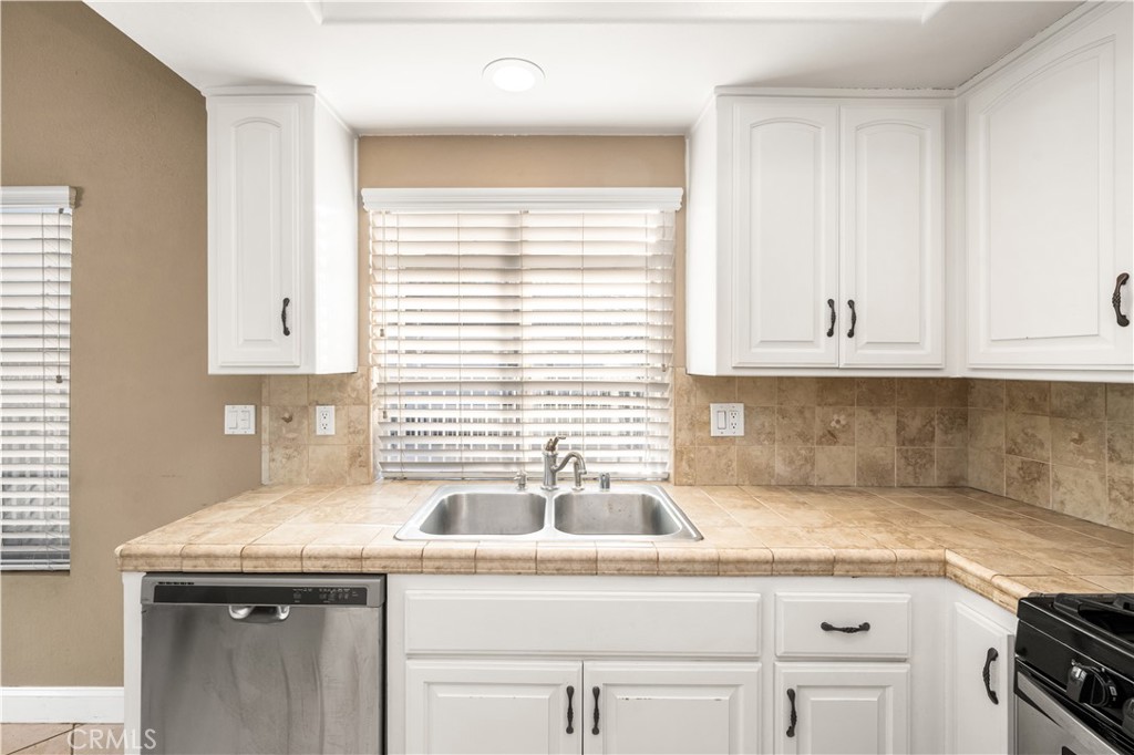 1062 Walnut Street, Unit C Tustin, CA 92780 - Photo 15 of 41 a kitchen with granite countertop a sink and a white wooden cabinets