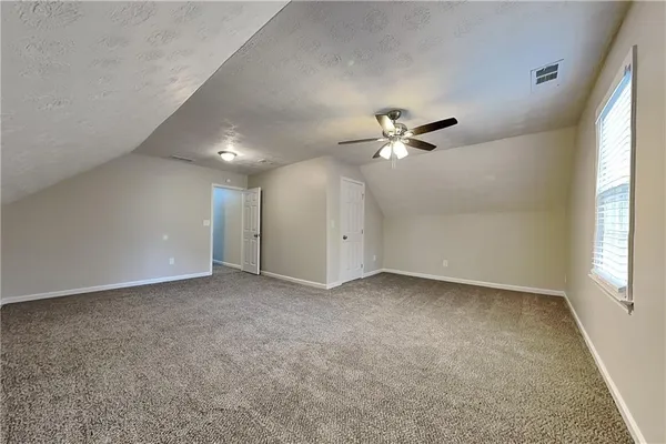 an empty room with fan and windows