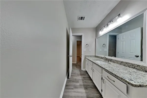 a bathroom with a granite countertop sink and a mirror
