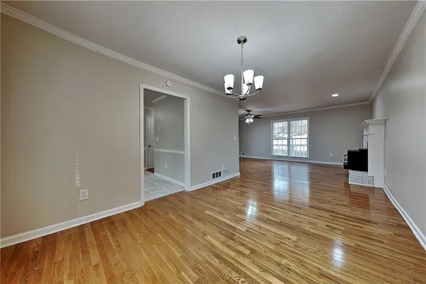a view of empty room with wooden floor and window