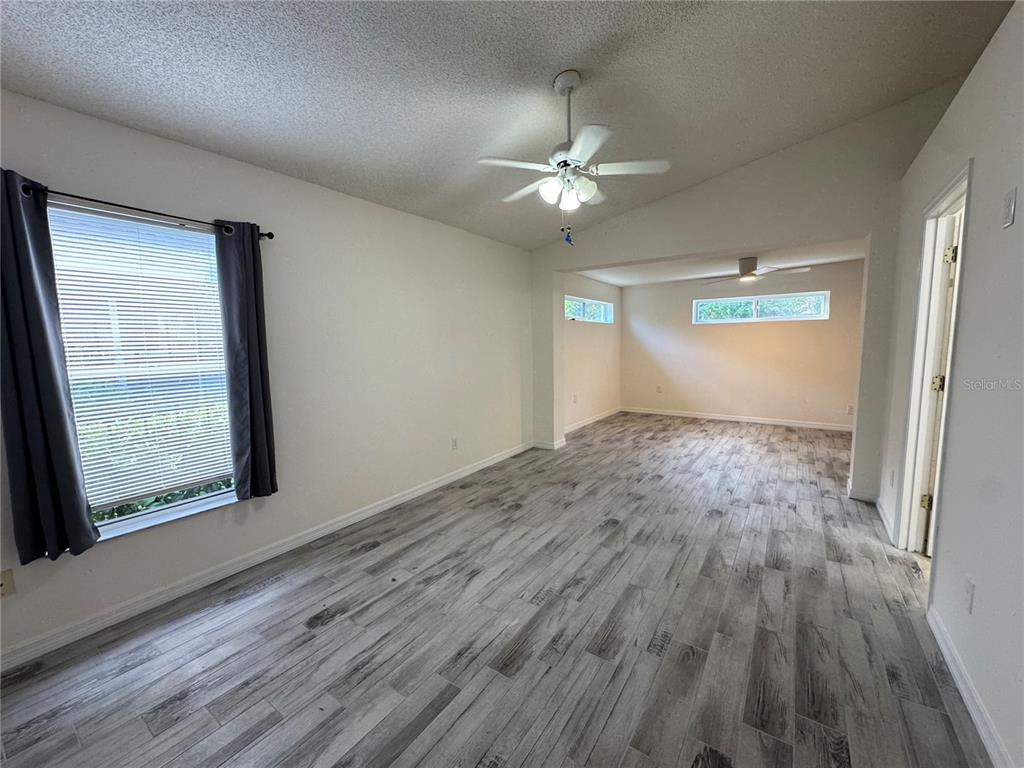 3350 Lake Tiny Circle Orlando, FL 32818 - Photo 16 of 27 an empty room with wooden floor fan and windows