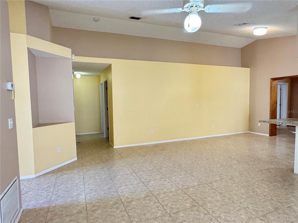 3350 Lake Tiny Circle Orlando, FL 32818 - Photo 4 of 27 an empty room with a chandelier fan and a large mirror