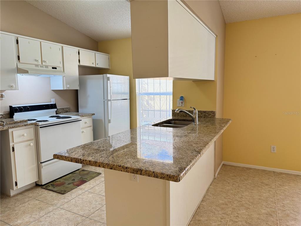 3350 Lake Tiny Circle Orlando, FL 32818 - Photo 7 of 27 a kitchen with granite countertop a sink a stove and refrigerator