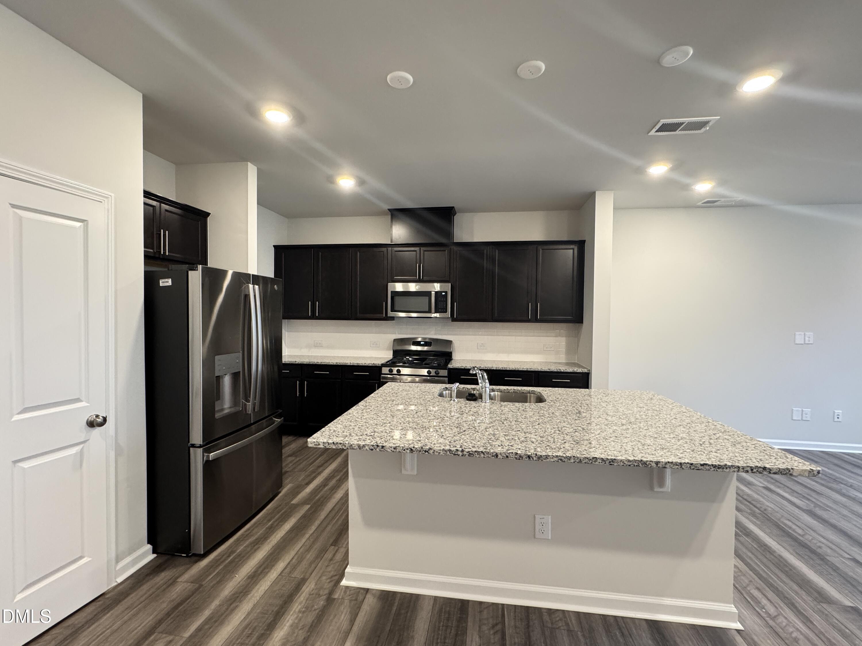 523 Hester Road Durham, NC 27703 - Photo 3 of 21 a large kitchen with a large counter top stainless steel appliances and a counter space