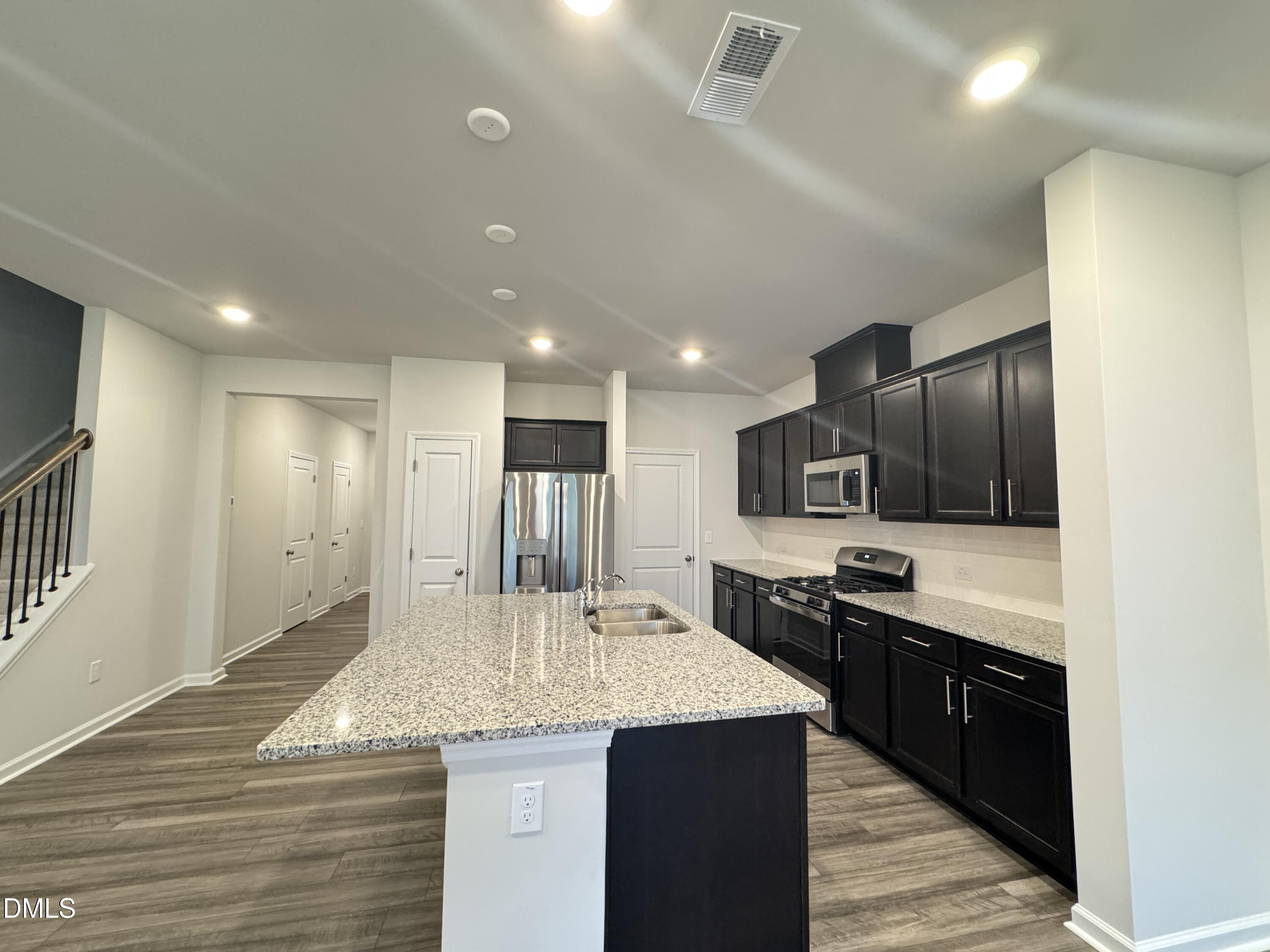 523 Hester Road Durham, NC 27703 - Photo 4 of 21 a kitchen with stainless steel appliances granite countertop a sink stove and refrigerator