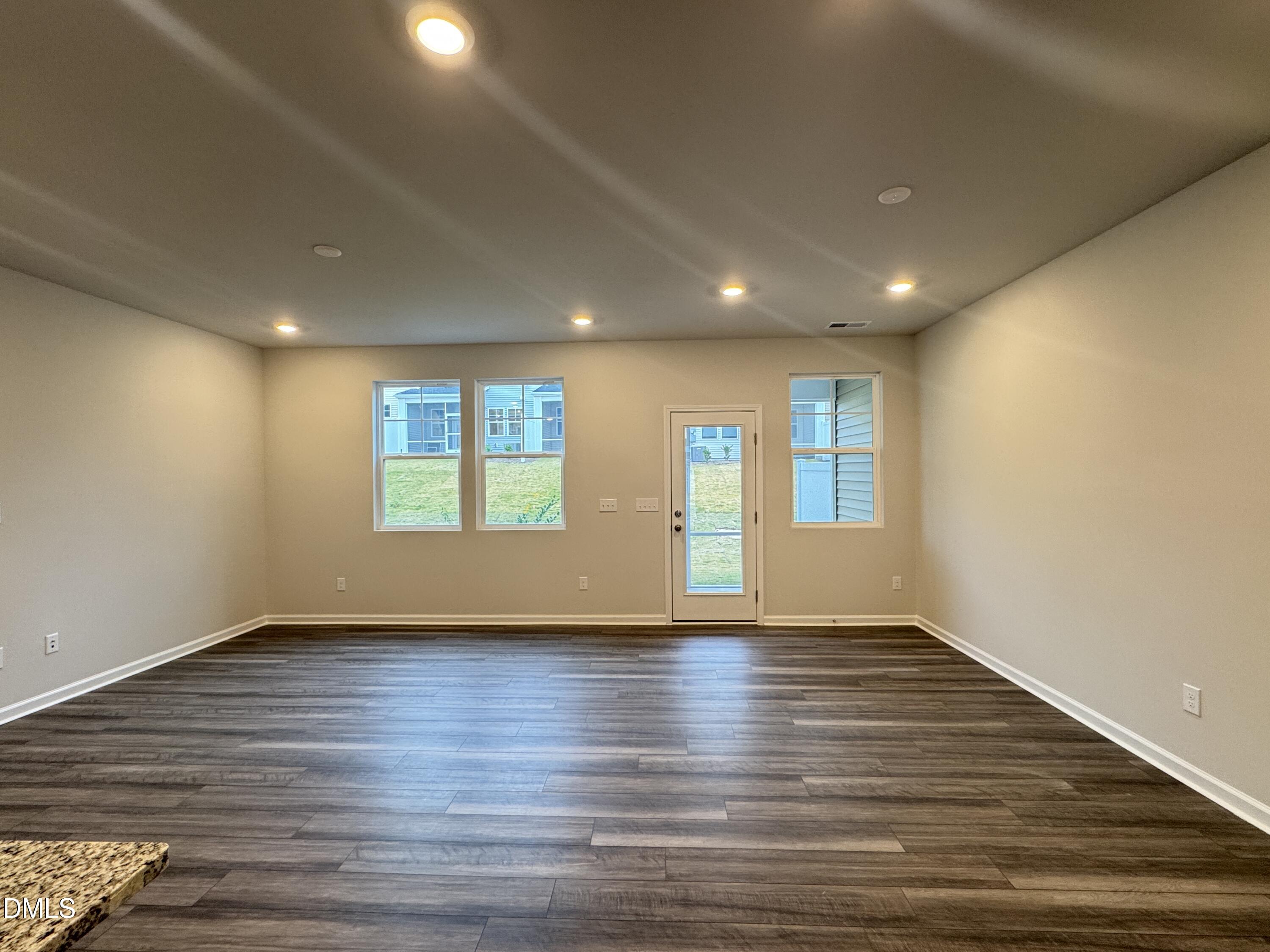523 Hester Road Durham, NC 27703 - Photo 5 of 21 a view of an empty room with wooden floor and a window