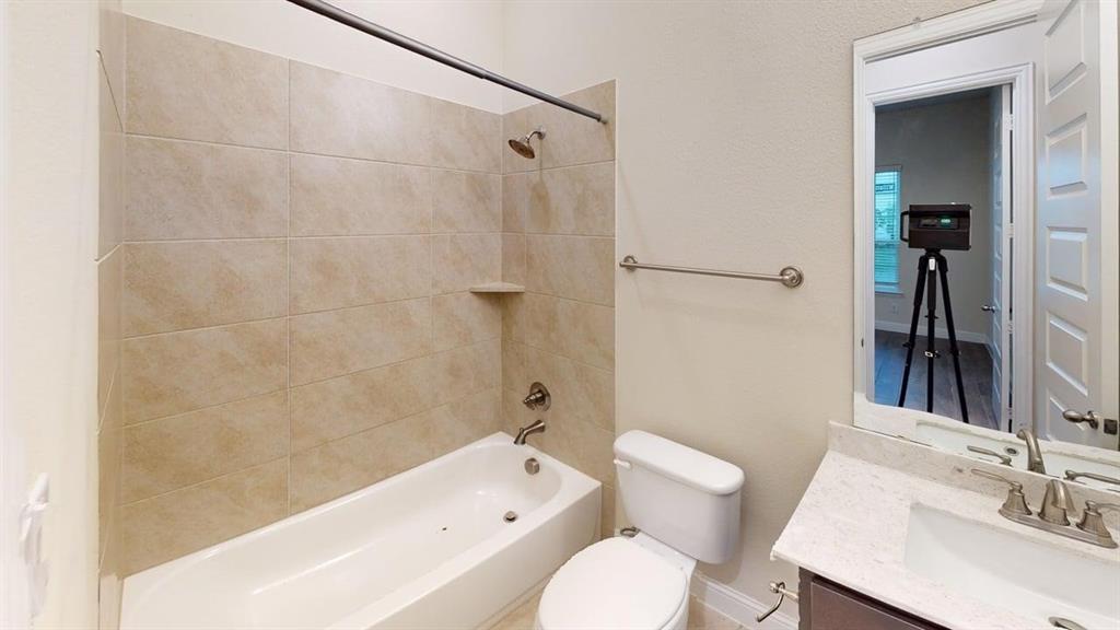 3314 Willena Road Melissa, TX 75454 - Photo 19 of 24 Bathtub with tiled surround, wall-mounted shower head, and built-in shelf