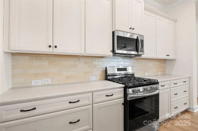 a kitchen with white cabinets and appliances