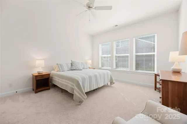 a bedroom with a bed and a large window