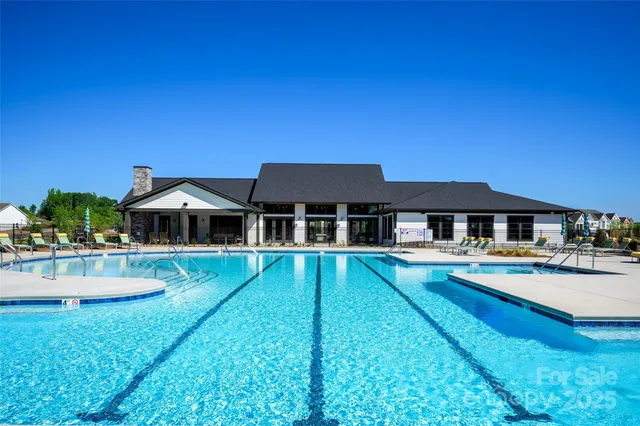 a view of a house with swimming pool and sitting area