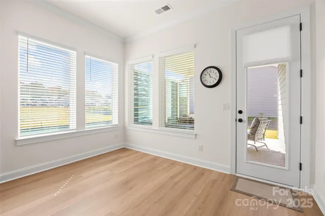 a view of empty room with window and wooden floor