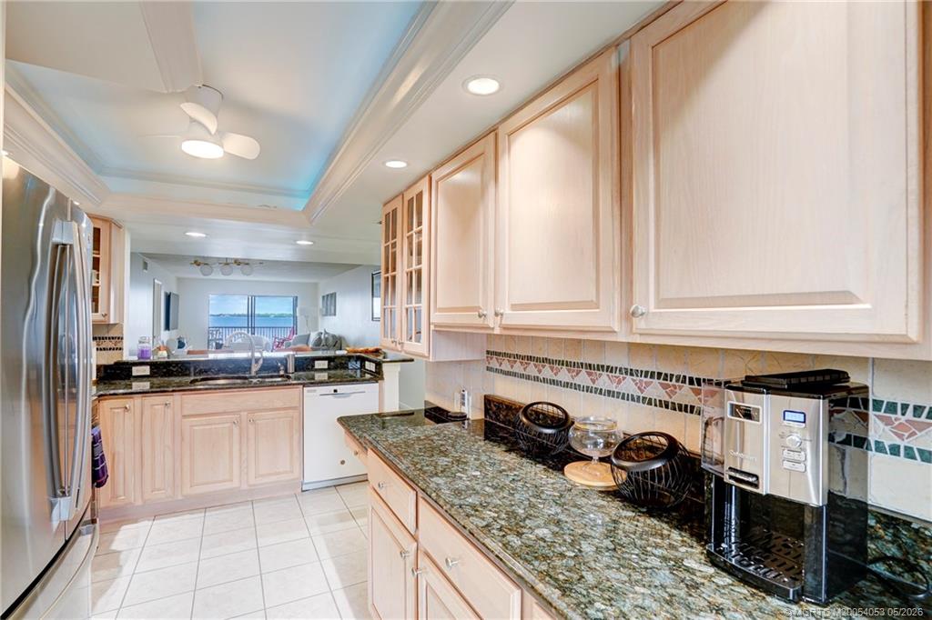10 Northeast Plantation Road, Unit 101 Jensen Beach, FL 34957 - Photo 33 of 53 a kitchen with stainless steel appliances granite countertop a stove a sink and a refrigerator