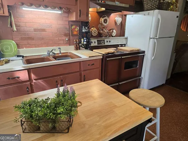 a kitchen with stainless steel appliances a stove a refrigerator and a dining table