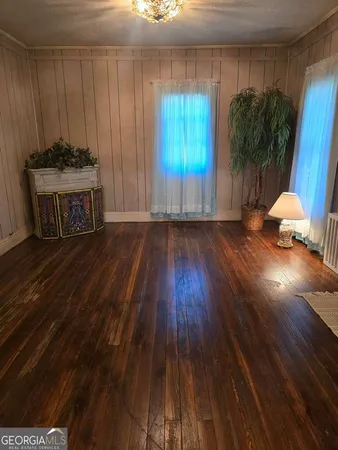 a view of a room with wooden floor and a window