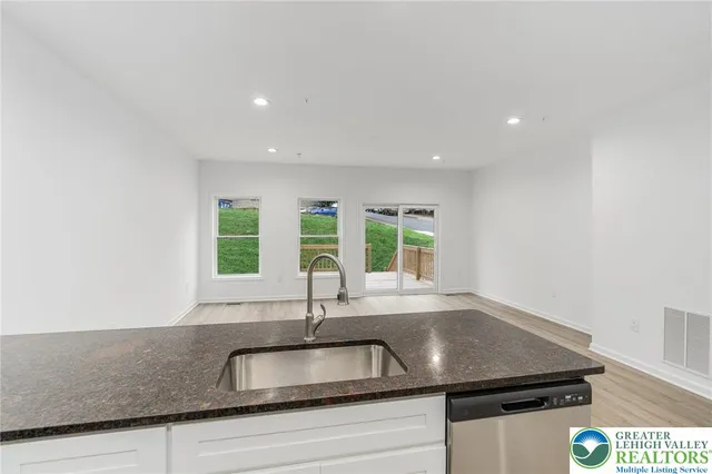 a kitchen with stainless steel appliances granite countertop a refrigerator a stove a sink and a microwave