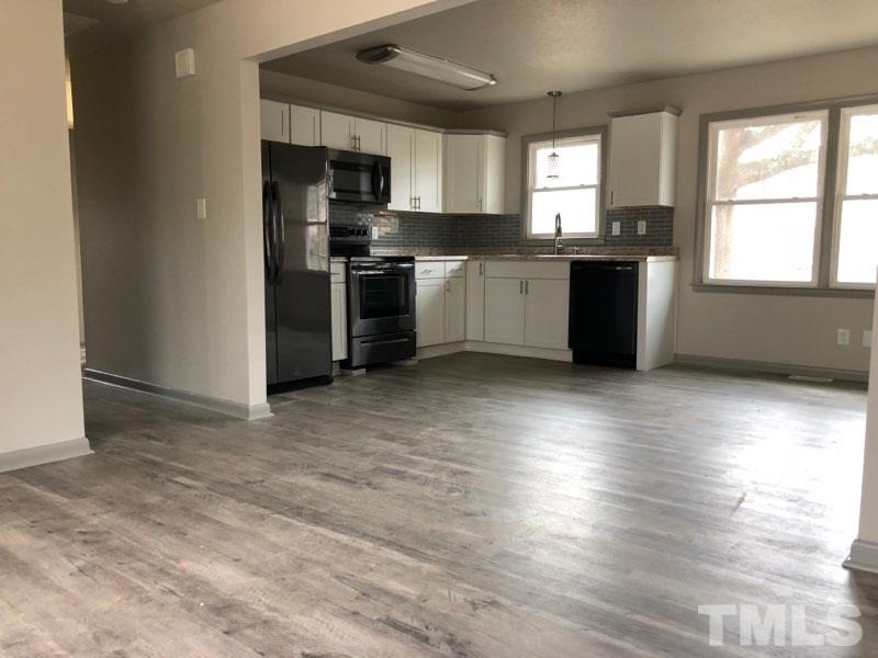 924 Seabrook Road Raleigh, NC 27610 - Photo 3 of 10 a kitchen with stainless steel appliances granite countertop a stove a sink dishwasher a refrigerator and a microwave oven with wooden floor