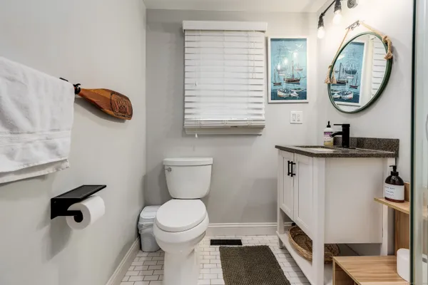 a bathroom with a toilet a sink and a mirror