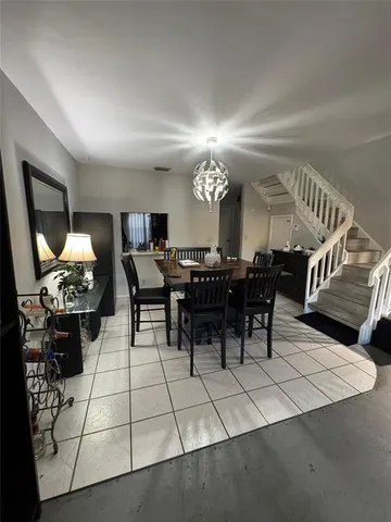 a living room with furniture a chandelier and a dining table