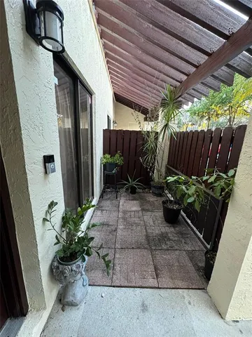 a view of a backyard with potted plants and wooden fence