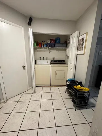 a kitchen with a refrigerator and white cabinets