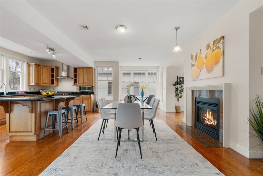 53 Winslow Road Brookline, MA 02446 - Photo 7 of 23 a living room with furniture a fireplace and a kitchen view